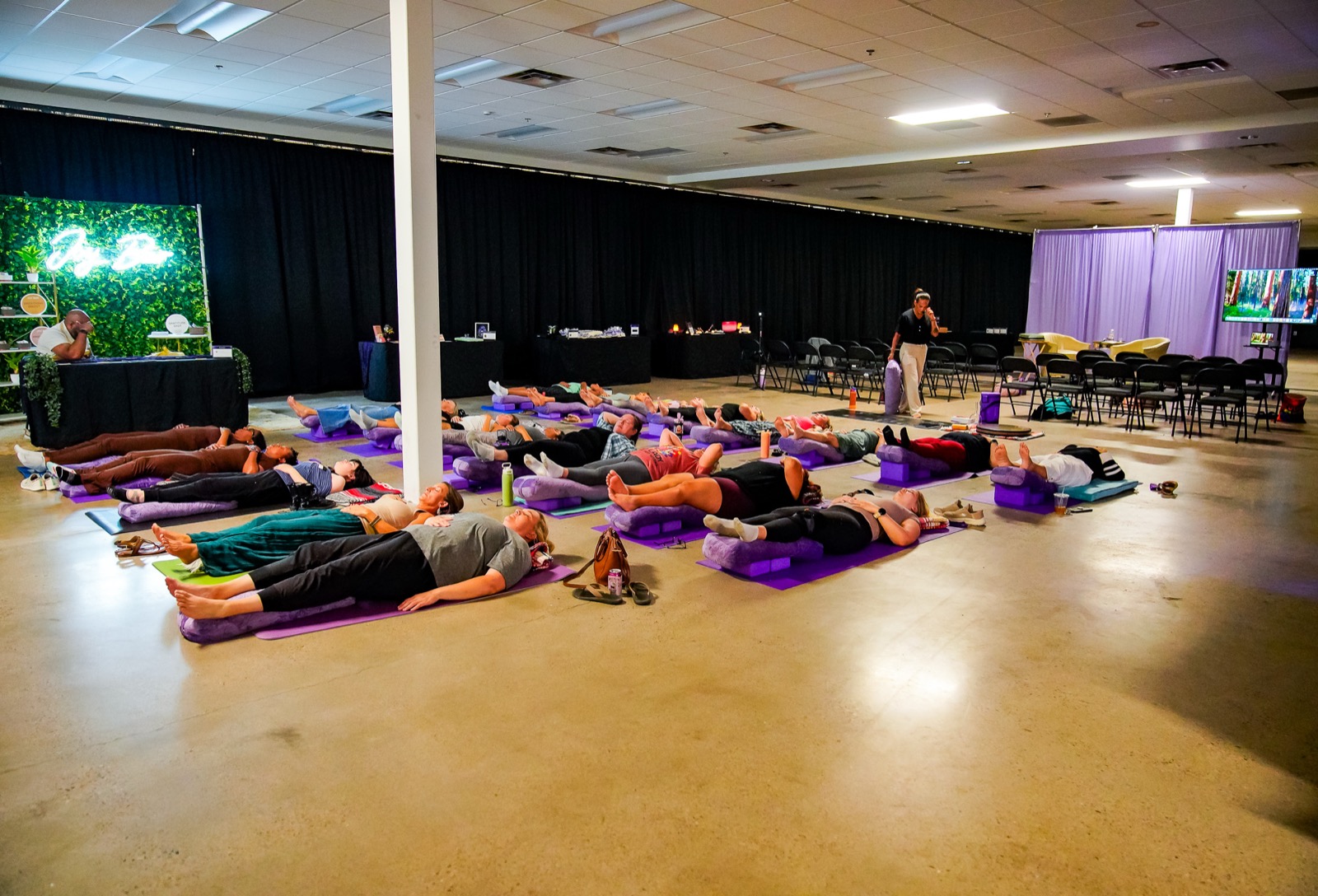 Mid-session: guests on purple mats as Erlinda walks the room